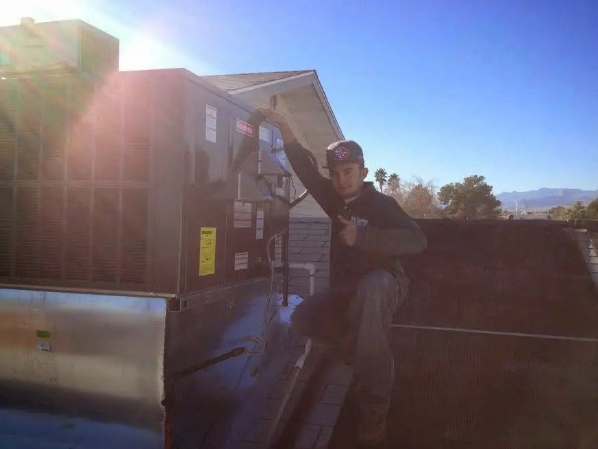 HVAC technician performing Heat Pump Repair on a rooftop unit in Pasadena